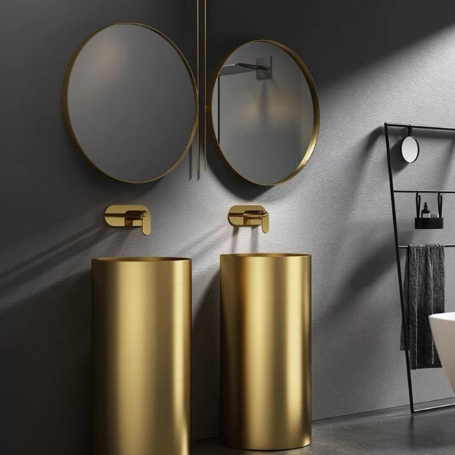 Dual gold pedestal basin installation in modern bathroom with wall mounted faucet