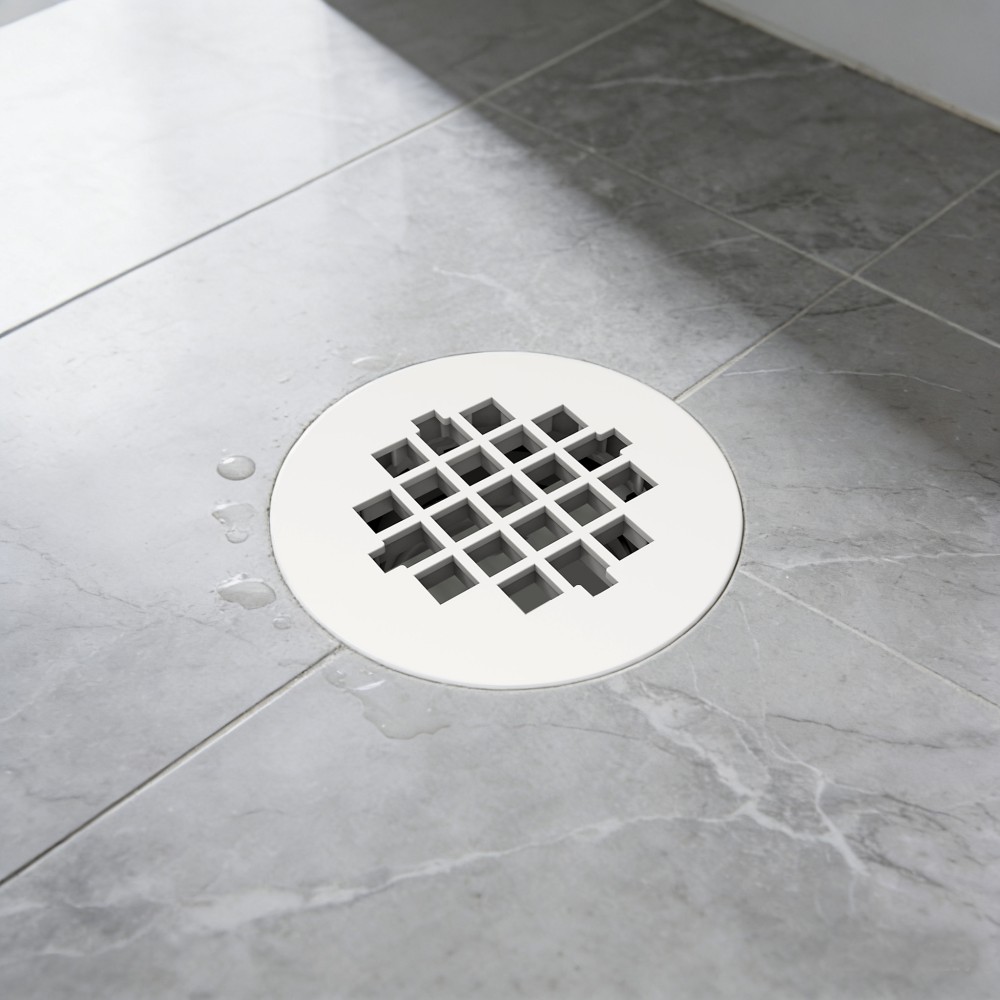 round shower drain cover installed on tiled floor with abs base