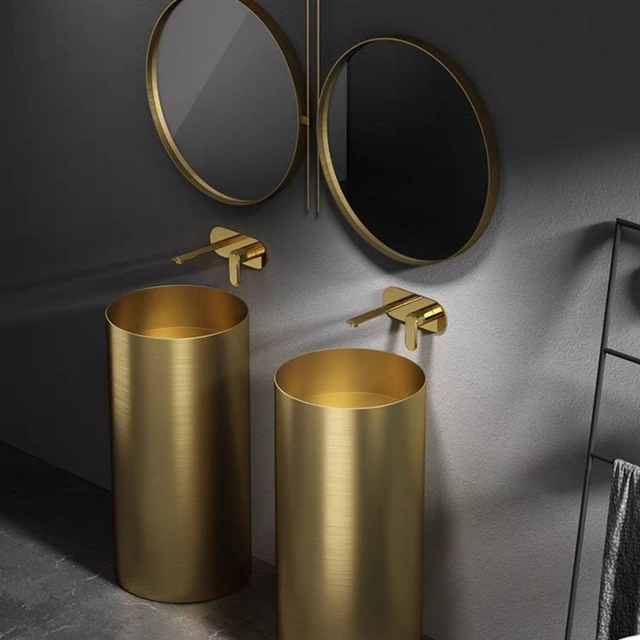 Twin stainless steel pedestal basins in gold with wall mounted taps