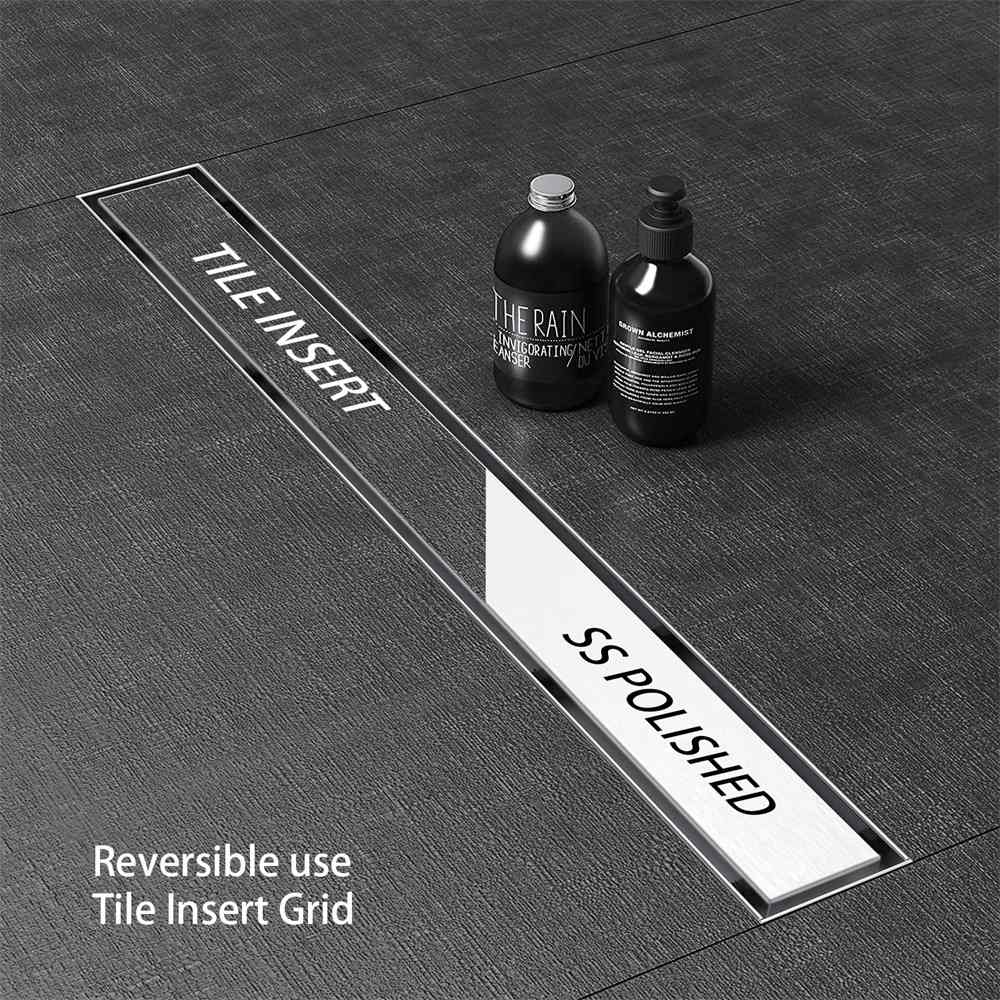Reversible tile insert stainless steel channel drain seamlessly integrated into dark flooring