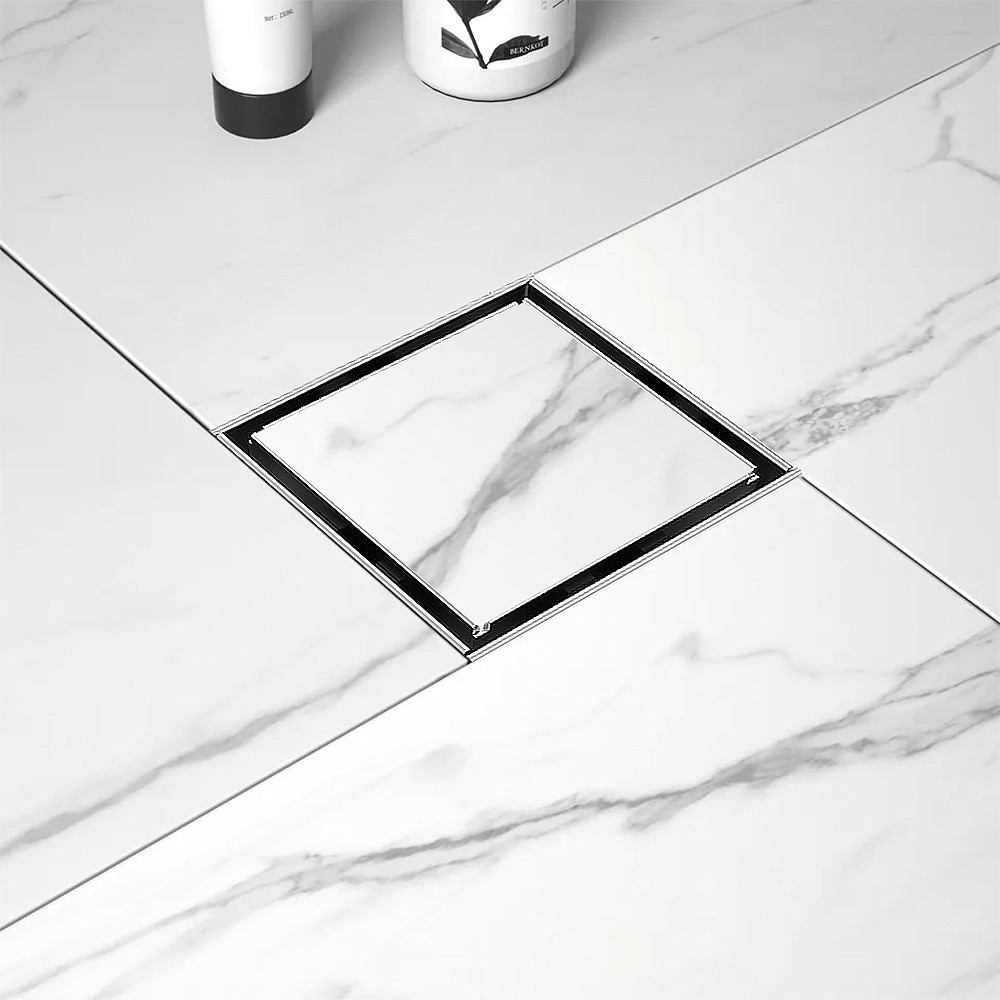 Tile insert stainless steel square drain seamlessly integrated into a light marble floor